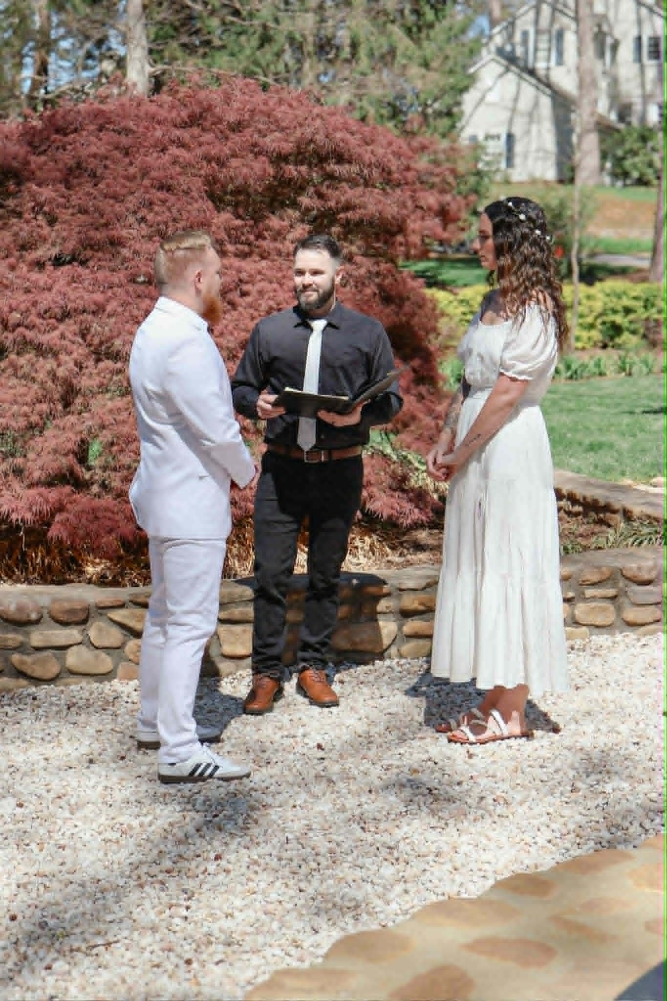 Garden wedding ceremony with the couple and officiant outdoors